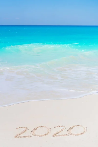 海の前の白い砂の上に書かれた2020年の手 — ストック写真