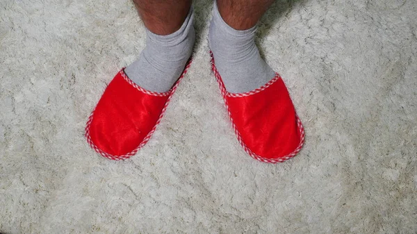 Beyaz Halıda Kırmızı Terlikler Giyen Erkeklerin Bacakları — Stok fotoğraf