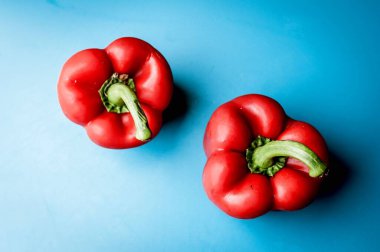 Mavi arka planda iki kırmızı sağlıklı biber. 