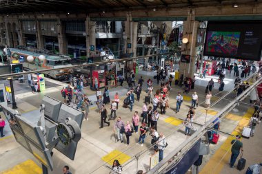 İnsanlar Gare du Nord 'un ana salonunda trenlerini bekliyorlar.