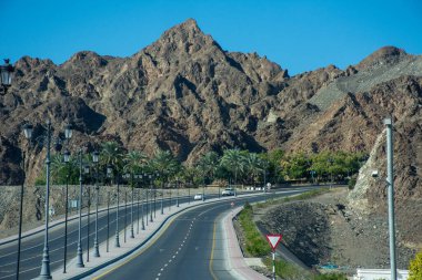 Mountain highway road with rocky mountains and blue sky clipart