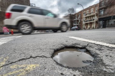 Montreal, Kanada 'da Laurier caddesinde onarılmamış büyük bir çukur.