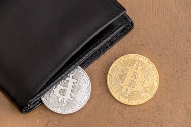 Bitcoin paraları deri bir cüzdandan çıkıyor.