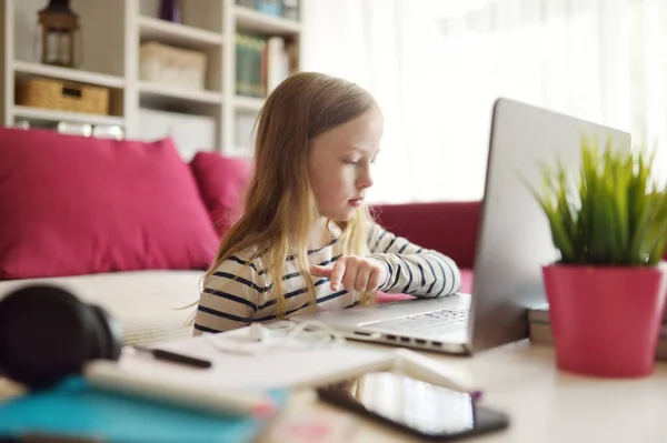 若い女子生徒が自宅でデジタルタブレットで宿題をしている 子供は勉強するためにガジェットを使用しています 子供のための教育と遠隔教育 検疫中のホームスクーリング — ストック写真