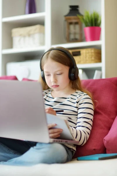若い女子生徒が自宅でデジタルタブレットで宿題をしている 子供は勉強するためにガジェットを使用しています 子供のための教育と遠隔教育 検疫中のホームスクーリング — ストック写真