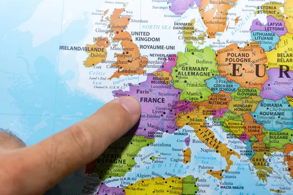 Finger pointing to a colorful country map of Paris, France in Europe