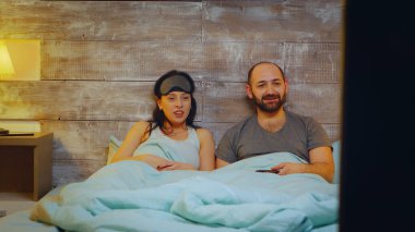 Yatakta pijama giyen neşeli çift