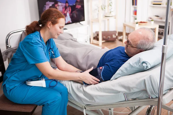 Nainen Sairaanhoitaja Tarkistaa Eläkkeellä Olevan Miehen Verenpaineen — kuvapankkivalokuva