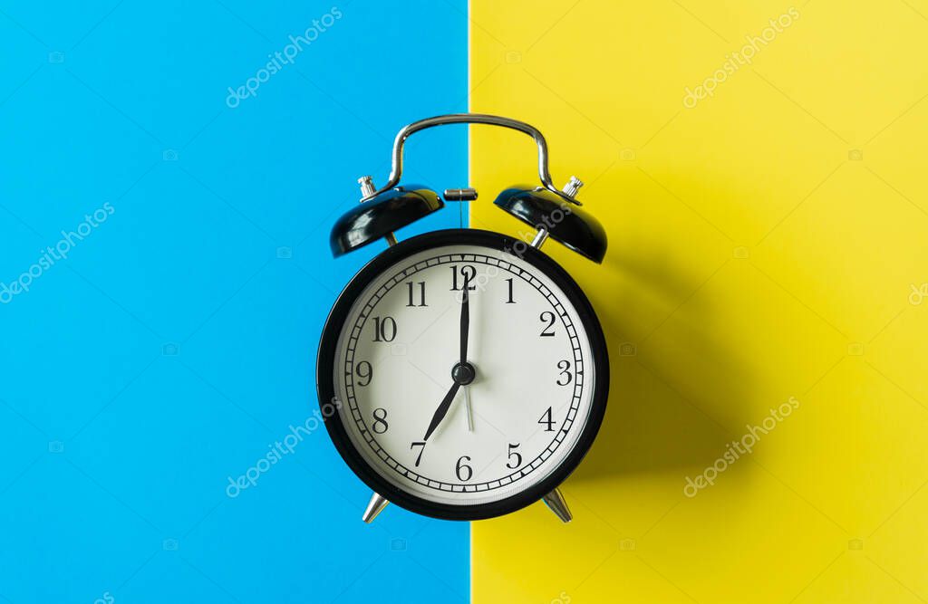 black alarm clock from 7 a.m. to 8 a.m. with bright yellow and b" 2023