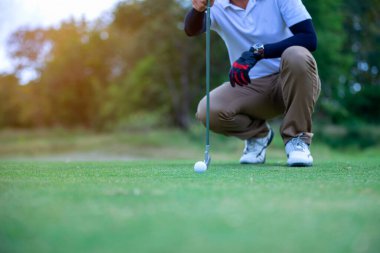 Golf oyuncusu yeşil çimlerin üzerine golf topu koymak için kontrol hattı