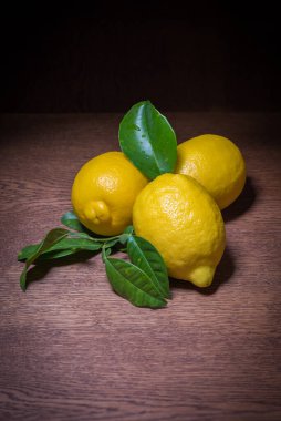 Yaprakları ve ahşap masasında limon dolu bir hayat