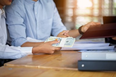 Evli aile çifti mutlu bir gülümseme bir kontrat kağıdı imzalayın ve bir yığın dolar verin.