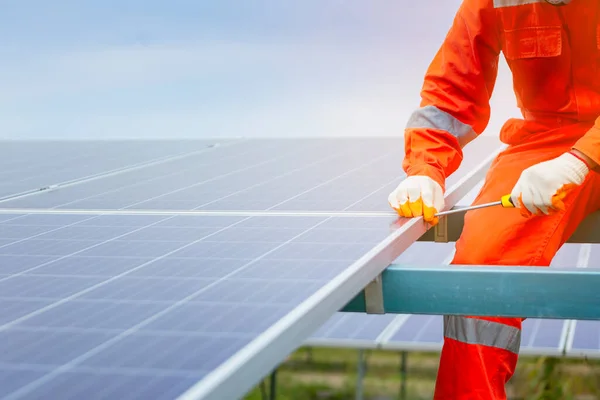 Engineers and workers in uniform and installs solid solar panels