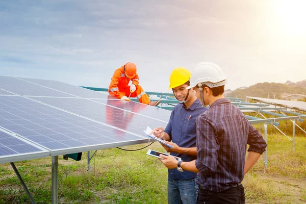 Engineers and workers in uniform and installs solid solar panels