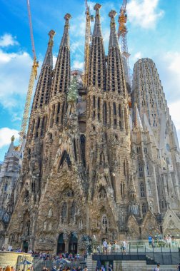 La Sagrada Familia Barcelona, İspanya 'da mavi gökyüzü fon üzerinde inşaat vinçleri ile