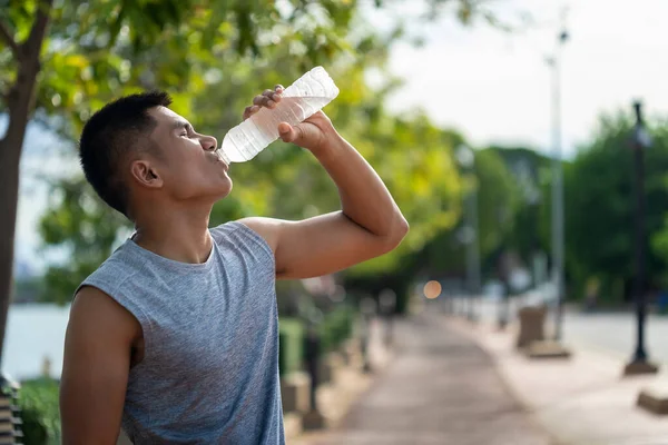 ハンサムな男は トレーニング後に渇いた水を飲んでいる — ストック写真