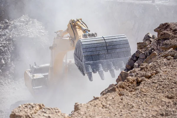 黄色の掘削機は 炭鉱で岩でダンプトラックを埋めている — ストック写真
