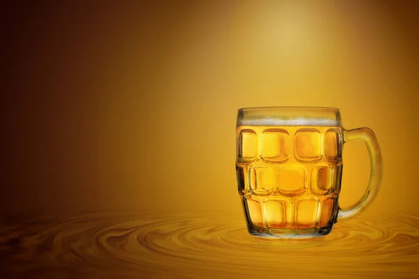 黄金色の背景の上に冷たいビールのガラス — ストック写真
