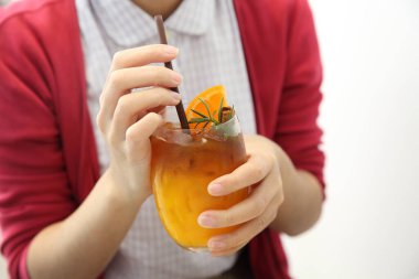 Genç bayan kafede taze portakal suyu içiyor.