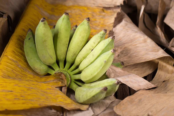 香蕉叶和木质背景下的黄色和绿色亚洲香蕉 — 图库照片