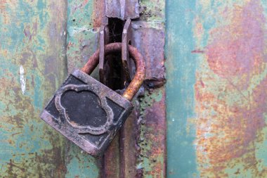 Eski çelik kilit hangar kapısını güvenli bir şekilde kilitliyor.