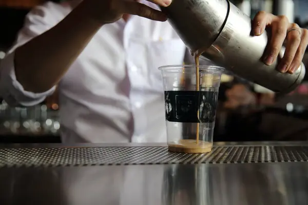 barista making coffee drink in coffee shop, close up