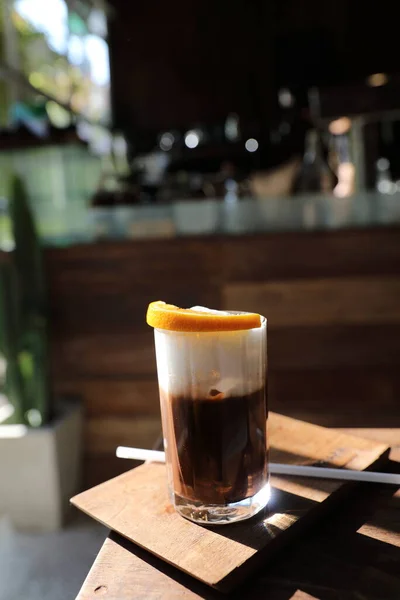 Turuncu Ahşap Arka Plan Üzerinde Siyah Kahve Buz — Stok fotoğraf