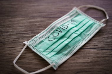 Surgical mask with corona virus (covid-19) text written.
