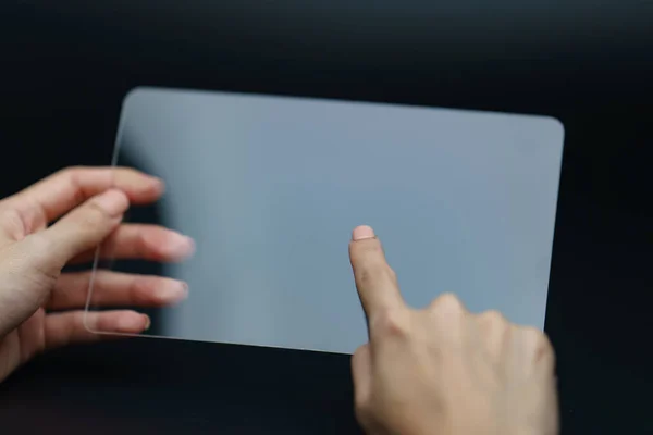 Hand holding and showing transparent tablet device. Business