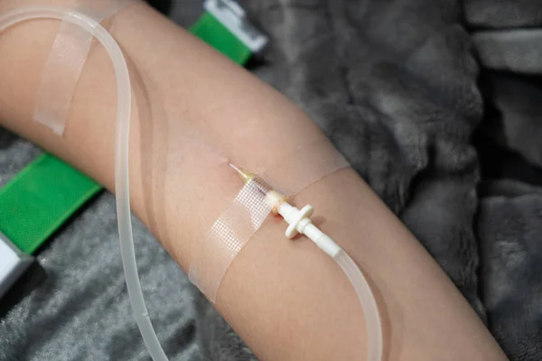 Patient with intravenous drip receiving saline solution. Inject