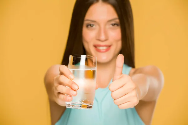 水のガラスを保持している若い笑顔の女性 — ストック写真
