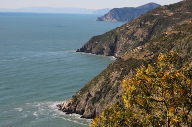 Mountains and rocks overlooking the Cinque Terre sea. Coastline with Mediterranean vegetation.