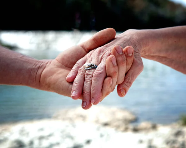 senior couple holding hands, close up