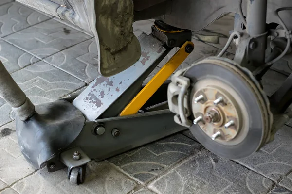 汽车的车轮拱与拆卸的车轮 加油站装有口径的制动器盘式汽车车轮 — 图库照片