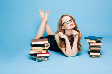 Kitapların yanında yatan seksi bayan öğretmen.