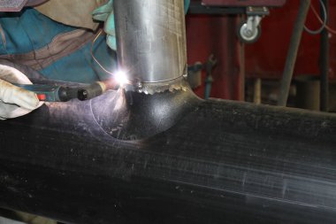 Endüstriyel fabrikada çelikle çalışan kaynakçı