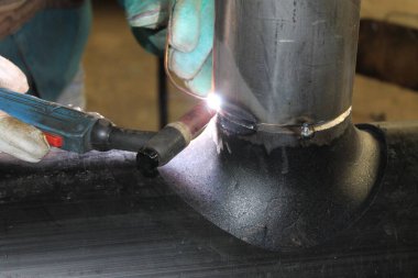 Endüstriyel fabrikada çelikle çalışan kaynakçı