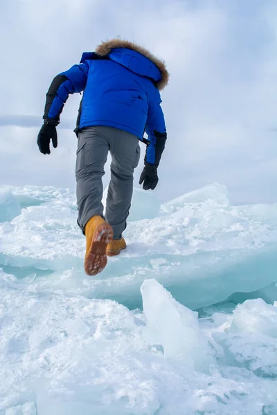 Man walking on ice in frozen lake at Lake Bikal, Russia