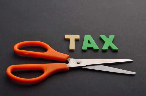 Business concept, tax cut, scissors and tax word