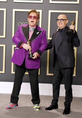 Elton John, Bernie Taupin Akademi Ödülleri sunumunda poz veriyor.