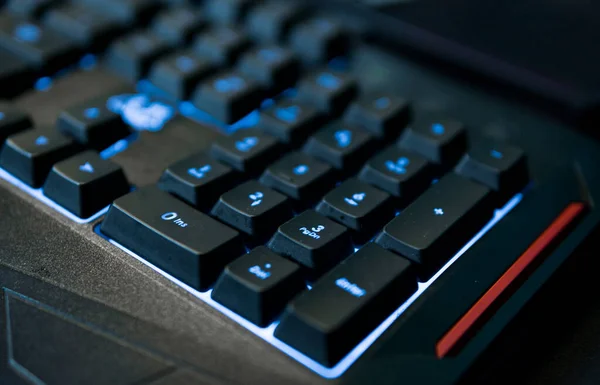 Gamer keyboard with colorful blue lights, modern gamer computer. Blue backlight, backlit on laptop or keyboard computer of gaming.
