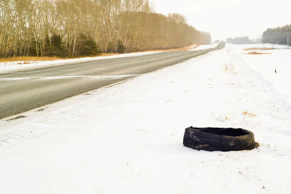 Torn Car Tire Truck Lies Snow Side Road — Zdjęcie stockowe