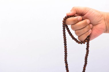 Beyaz arka planda tespihi tutan kişi