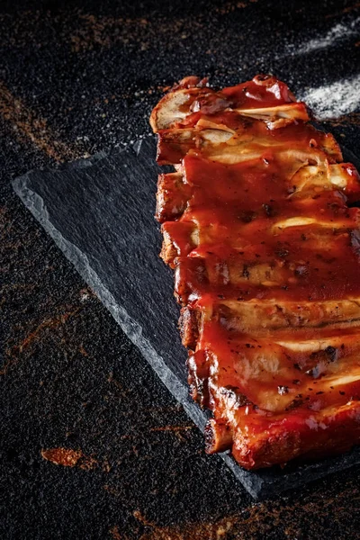 Closeup Baked Pork Ribs Barbecue Sauce Slate Bottom Baked Potatoes — Stockfoto