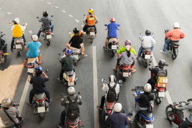 Arka planda trafik ışığı olan kavşakta motosiklet