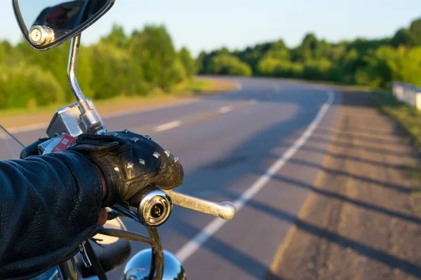 オートバイのコントロールハンドルと道路の眺め上のバイカーの手のクローズアップ — ストック写真