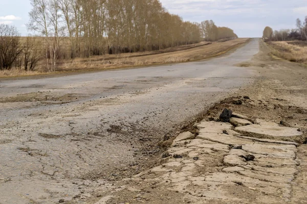 田舎の道を歩いている トラック上の損傷したアスファルト — ストック写真