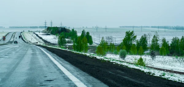 夏の初めに雪が降った郊外の風景 トワイライトと霧 危険な道 — ストック写真