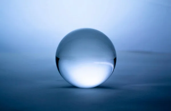 蓝色梯度背景下透明的水晶玻璃球球 — 图库照片