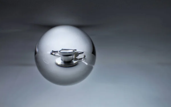水晶玻璃球球体在灰度梯度背景下显示内科听诊器 — 图库照片